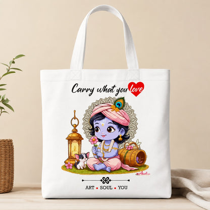 White cotton canvas tote bag featuring cute Baby Krishna artwork with the text “Carry what you love”