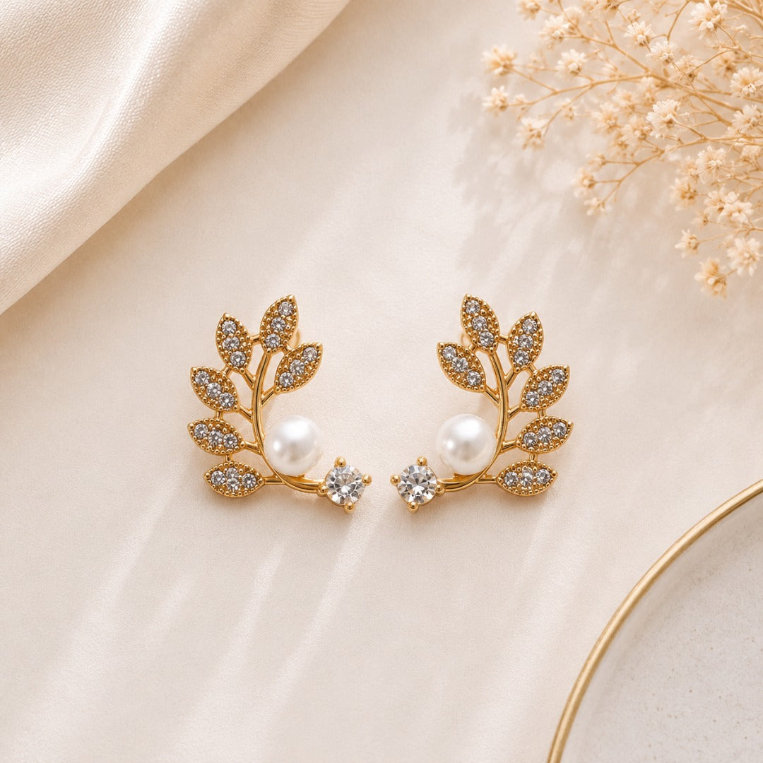 Angled view of elegant pearl floral and leaf stud earrings set for women.