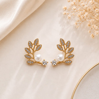 Angled view of elegant pearl floral and leaf stud earrings set for women.