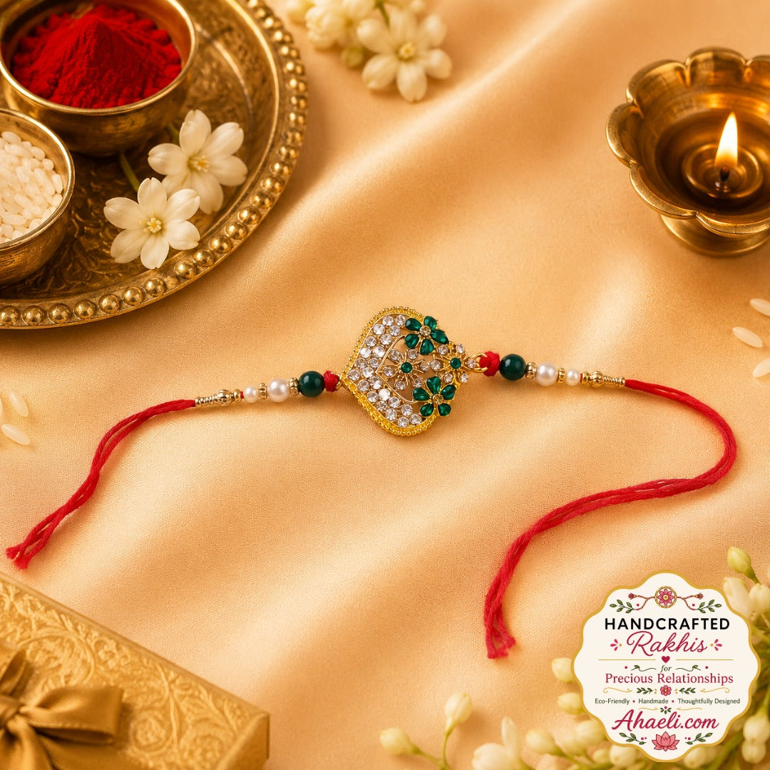 A beautifully handcrafted floral rakhi featuring emerald green stones, sparkling crystals, and pearl accents, designed to make Raksha Bandhan celebrations truly special.