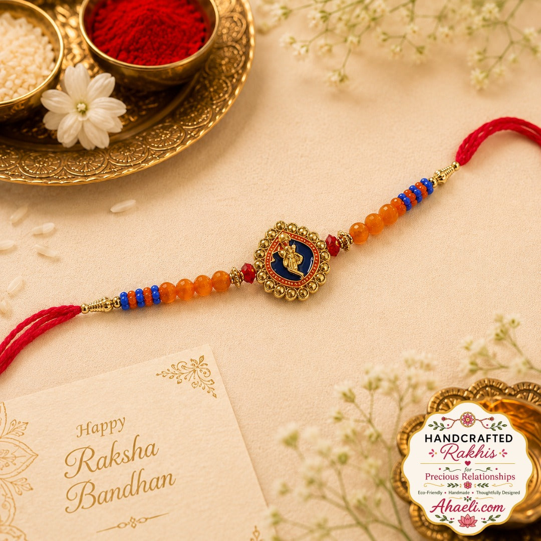 Handcrafted Krishna motif rakhi with orange and blue beads and decorative metal centerpiece
