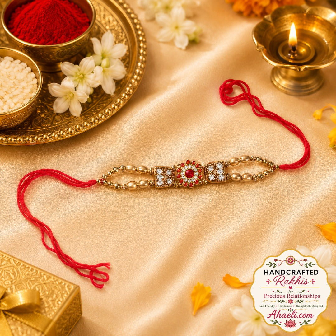 An elegant handcrafted rakhi featuring ruby-colored stones, crystal embellishments, and premium metal detailing for a timeless Raksha Bandhan celebration.