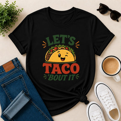 Women's black cotton T-shirt featuring a cute smiling taco illustration and the funny phrase "Let's Taco 'Bout It".