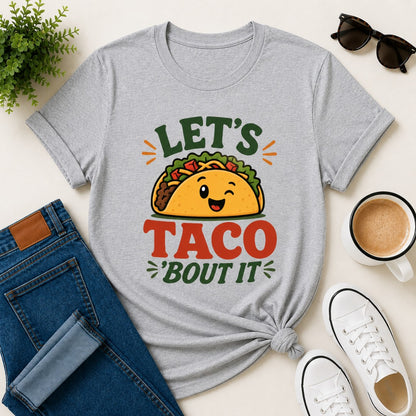 Women's gray cotton T-shirt featuring a cute smiling taco illustration and the funny phrase "Let's Taco 'Bout It".